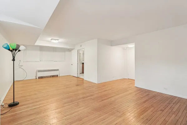 a view of empty room with wooden floor