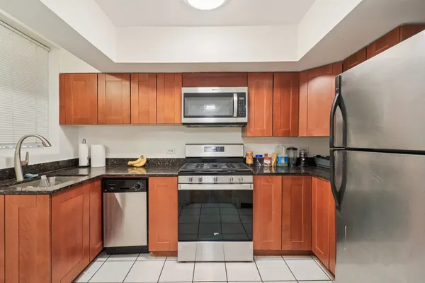 a kitchen with granite countertop a stove top oven sink and cabinets