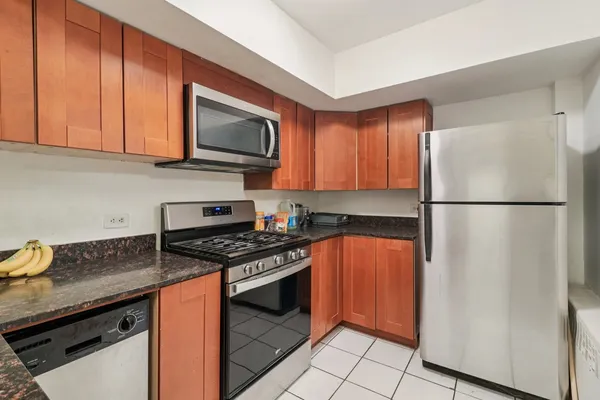 a kitchen with stainless steel appliances granite countertop a refrigerator stove top oven and sink
