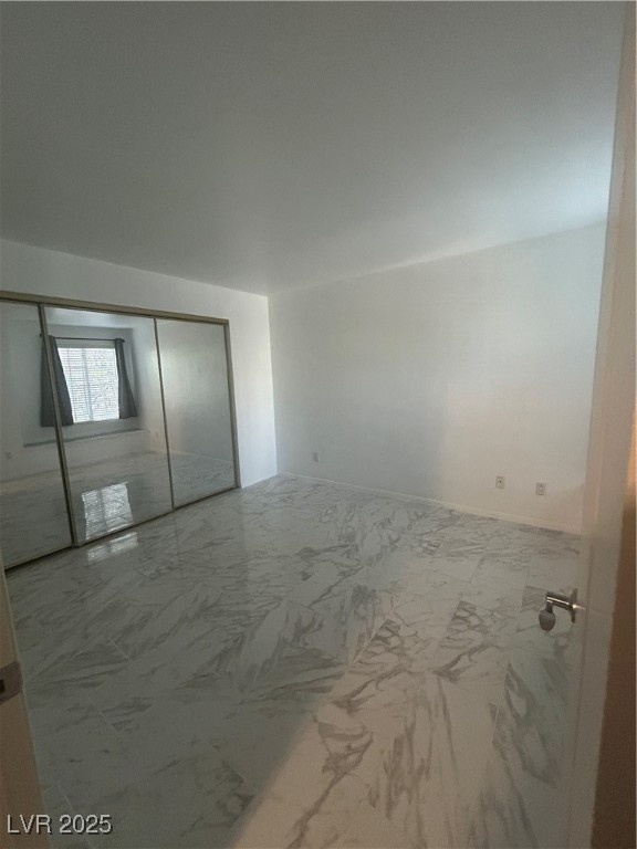 3145 East Flamingo Road, Unit 1014 Las Vegas, NV 89121 - Photo 14 of 17 Unfurnished bedroom featuring marble look tile flooring and a closet