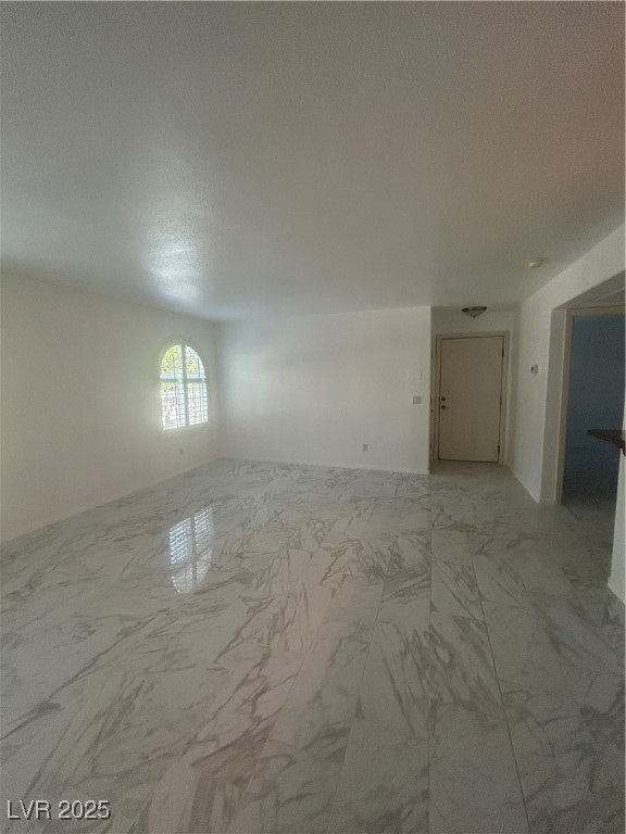 3145 East Flamingo Road, Unit 1014 Las Vegas, NV 89121 - Photo 7 of 17 Unfurnished room featuring light marble finish floors and a textured ceiling