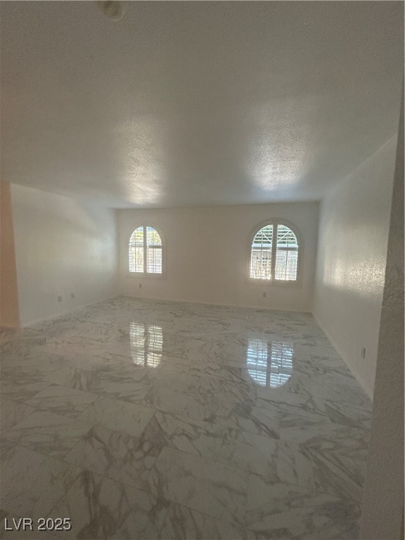 3145 East Flamingo Road, Unit 1014 Las Vegas, NV 89121 - Photo 8 of 17 Unfurnished room featuring healthy amount of natural light, a textured ceiling, and marble look tile flooring