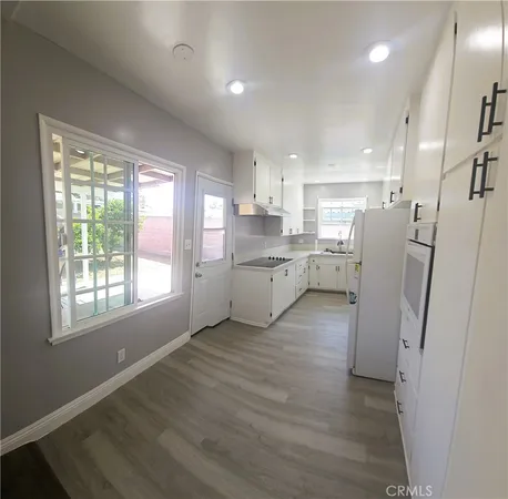 a view of a kitchen with a sink wooden cabinets and a window