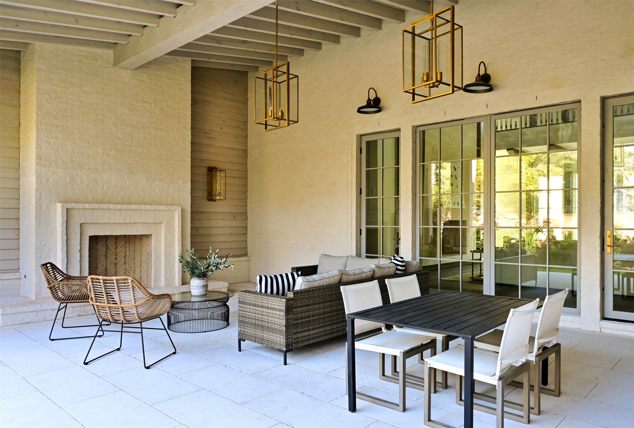 11710 Wendover Lane Houston, TX 77024 - Photo 46 of 50 Covered outdoor living area with fireplace, wood-beamed ceiling, and dining space with access to both the main living space and kitchen