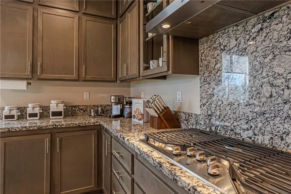 a kitchen with stainless steel appliances kitchen island granite countertop a stove and cabinets