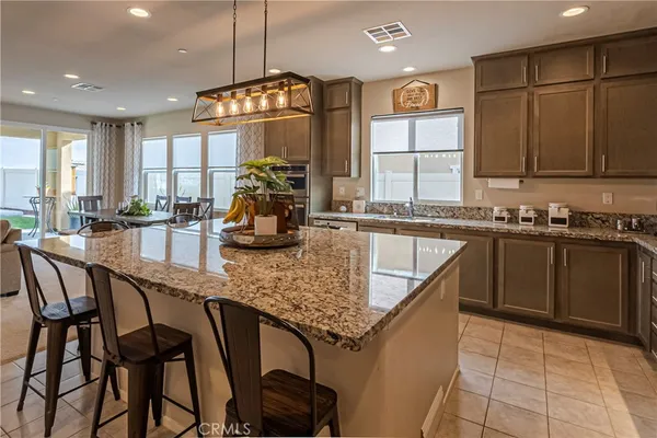 a living room with furniture granite floor and a chandelier