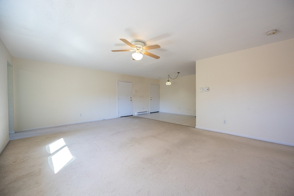 3 Dailey Street, Unit J Attleboro, MA 02703 - Photo 3 of 24 an empty room with a window and a ceiling fan