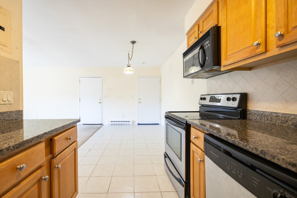 3 Dailey Street, Unit J Attleboro, MA 02703 - Photo 9 of 24 a kitchen with stainless steel appliances granite countertop a sink stove and cabinets