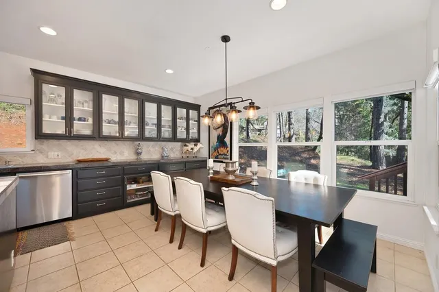a dining table with chairs and kitchen view