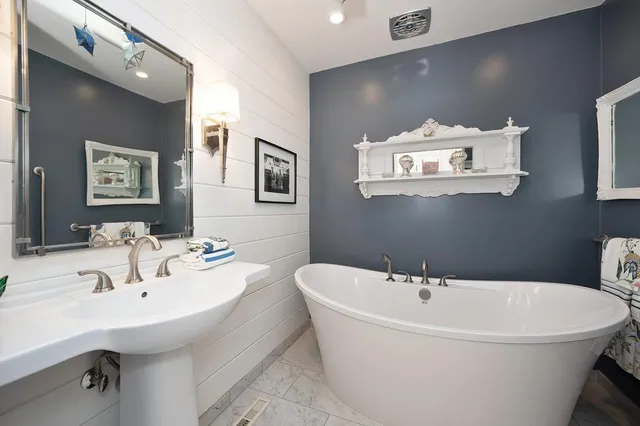 a white bath tub sitting next to a white sink