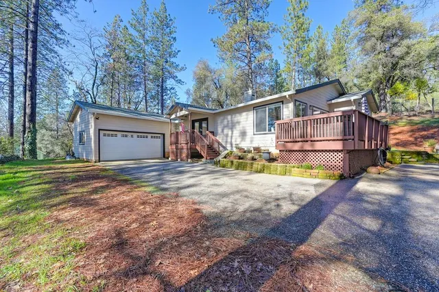 a view of a house with backyard and trees