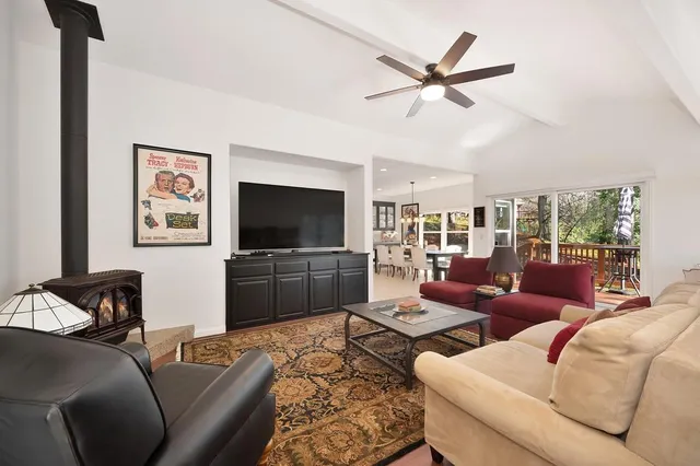 a living room with furniture a ceiling fan and a flat screen tv