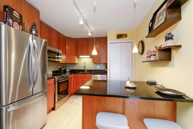 3033 North Sheridan Road, Unit 701 Chicago, IL 60657 - Photo 3 of 13 a kitchen with stainless steel appliances granite countertop a sink a stove and refrigerator