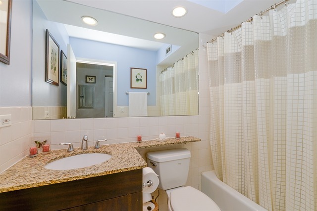 3033 North Sheridan Road, Unit 701 Chicago, IL 60657 - Photo 9 of 13 a bathroom with a granite countertop sink and a mirror
