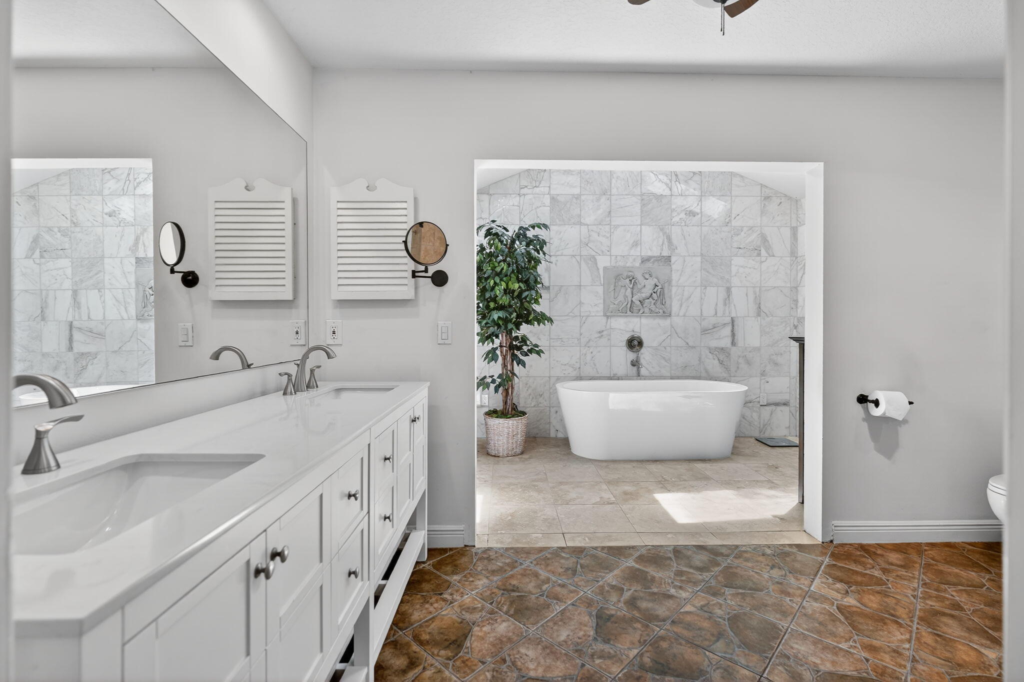 5741 Southeast Winged Foot Drive Stuart, FL 34997 - Photo 18 of 58 a spacious bathroom with a double vanity sink a mirror and a bathtub