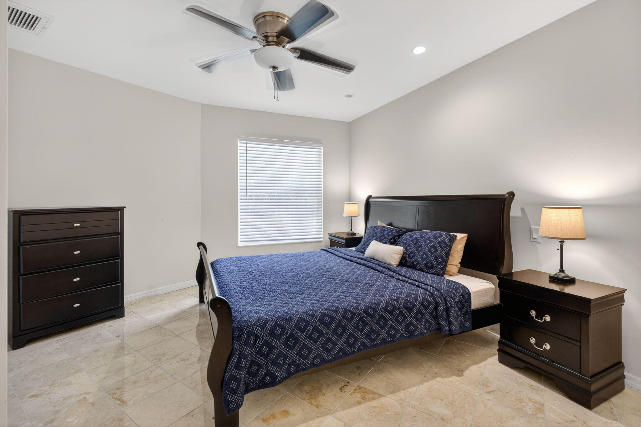 5741 Southeast Winged Foot Drive Stuart, FL 34997 - Photo 27 of 58 a bedroom with a bed and a lamp