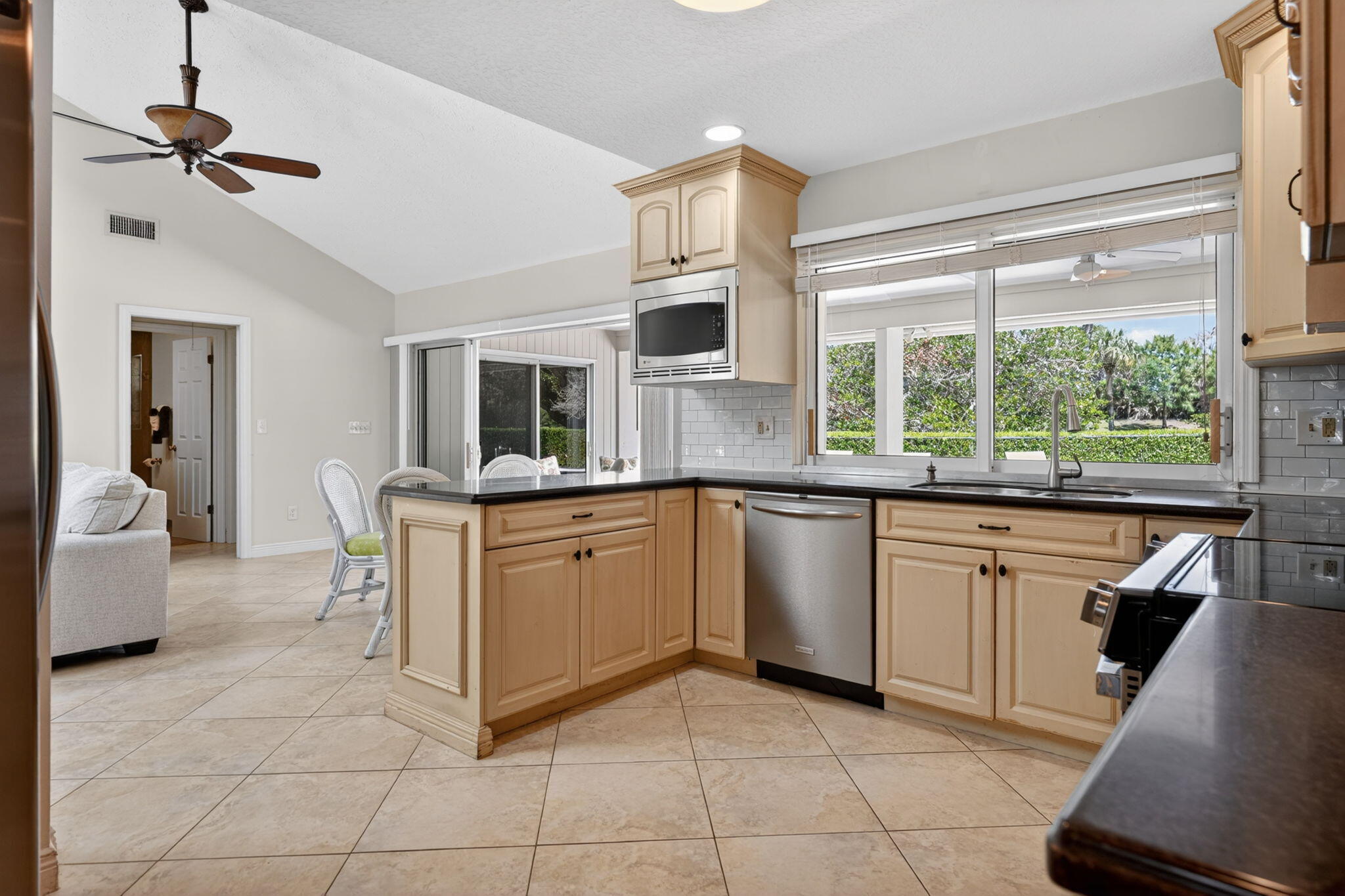 5741 Southeast Winged Foot Drive Stuart, FL 34997 - Photo 7 of 58 a kitchen with stainless steel appliances granite countertop a stove a sink and a microwave