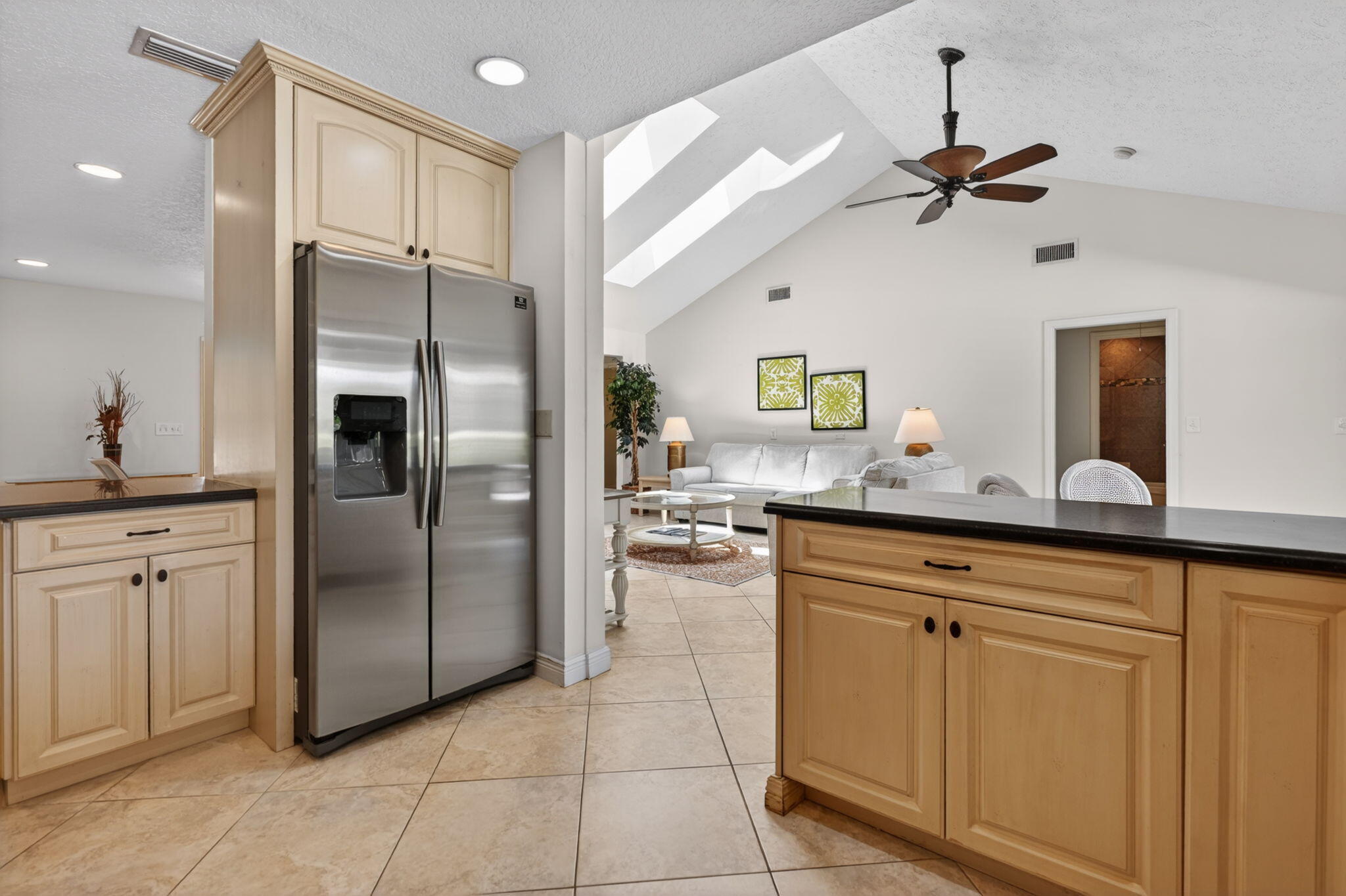 5741 Southeast Winged Foot Drive Stuart, FL 34997 - Photo 8 of 58 a kitchen with stainless steel appliances granite countertop a refrigerator a sink a stove and white cabinets