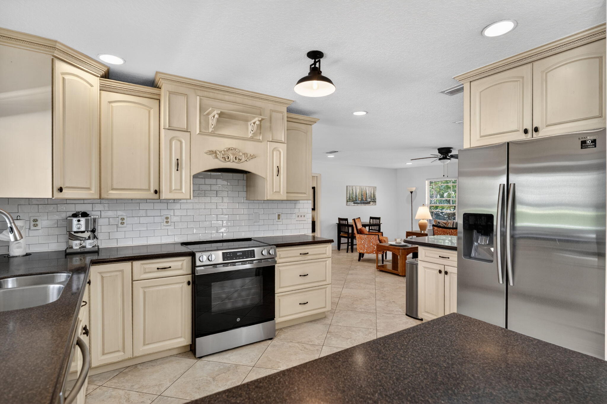 5741 Southeast Winged Foot Drive Stuart, FL 34997 - Photo 9 of 58 a kitchen with granite countertop white cabinets and stainless steel appliances