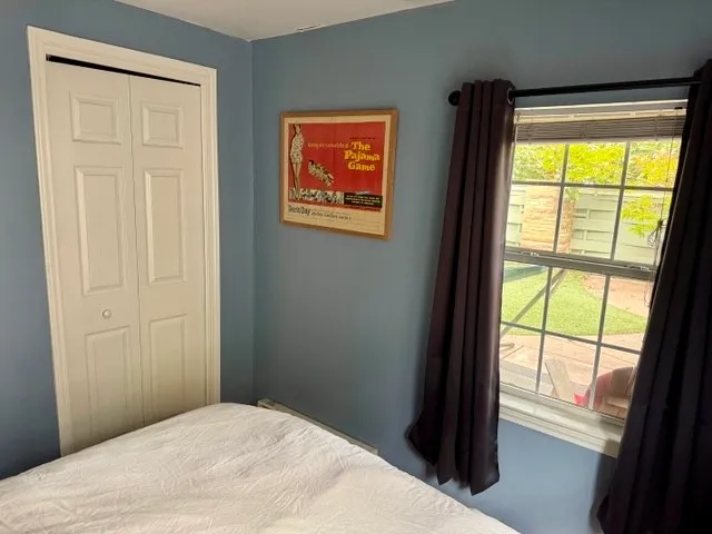 a bedroom with a bed and a window