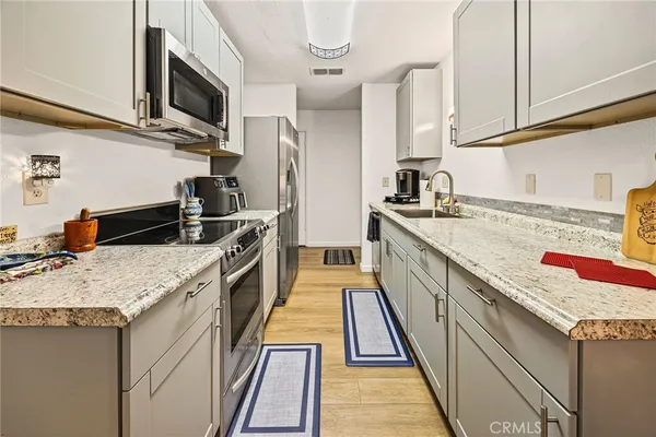 a kitchen with stainless steel appliances granite countertop a sink stove and refrigerator