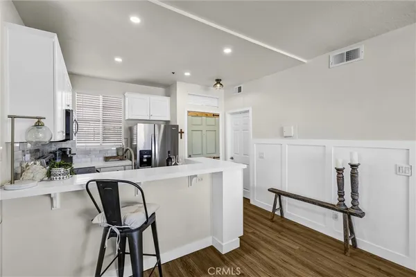 a kitchen with kitchen island a counter top space a sink stainless steel appliances and cabinets