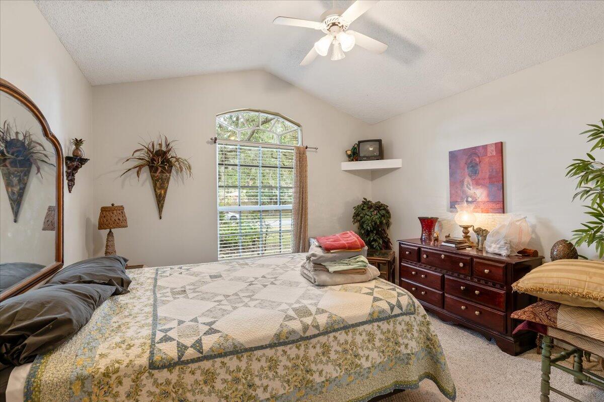 8006 Eden Road Fort Pierce, FL 34951 - Photo 12 of 25 a bedroom with a bed and a chandelier