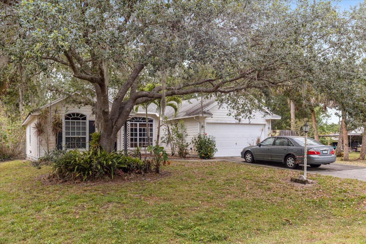 8006 Eden Road Fort Pierce, FL 34951 - Photo 2 of 25 a front view of a house with a garden