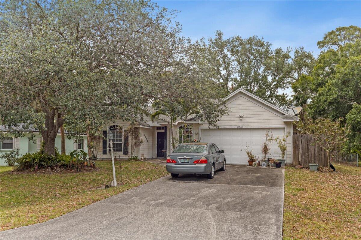 8006 Eden Road Fort Pierce, FL 34951 - Photo 3 of 25 a front view of a house with a yard and garage