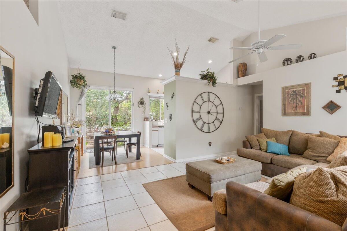 8006 Eden Road Fort Pierce, FL 34951 - Photo 6 of 25 a living room with furniture a fireplace kitchen view and a large window