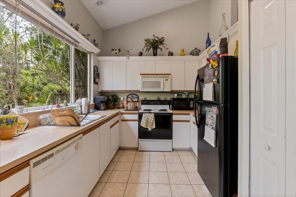 8006 Eden Road Fort Pierce, FL 34951 - Photo 8 of 25 a kitchen with stainless steel appliances a refrigerator sink and cabinets