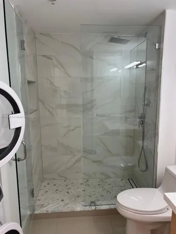a bathroom with a toilet and a shower