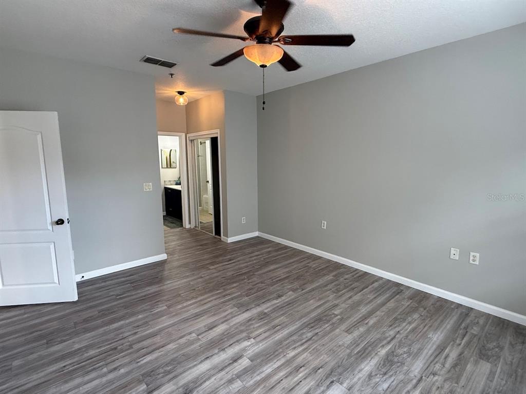 4817 Cypress Woods Drive, Unit 5203 Orlando, FL 32811 - Photo 13 of 22 a view of empty room with wooden floor and fan