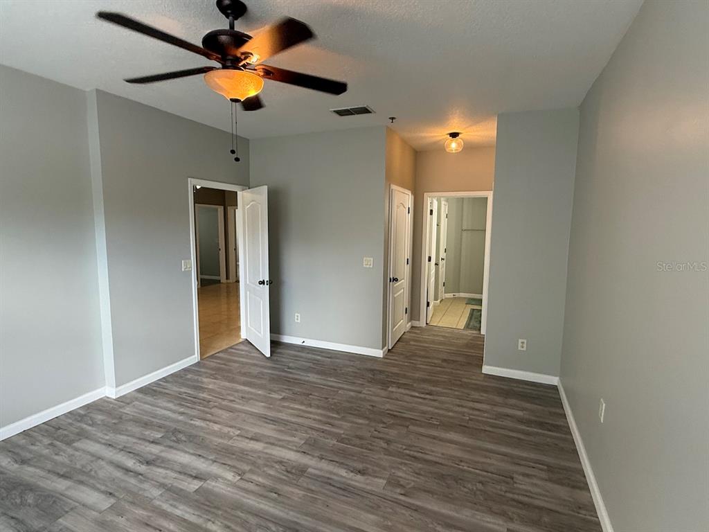 4817 Cypress Woods Drive, Unit 5203 Orlando, FL 32811 - Photo 14 of 22 a view of empty room with wooden floor and fan