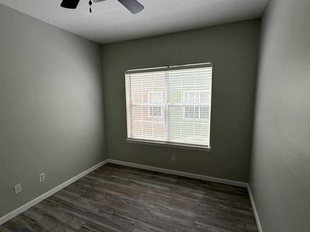 4817 Cypress Woods Drive, Unit 5203 Orlando, FL 32811 - Photo 17 of 22 a view of an empty room with wooden floor and a window
