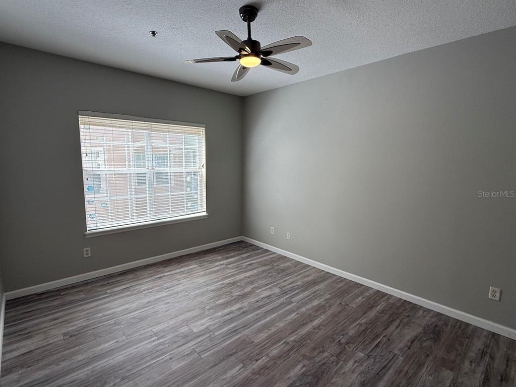 4817 Cypress Woods Drive, Unit 5203 Orlando, FL 32811 - Photo 19 of 22 wooden floor in an empty room with a window