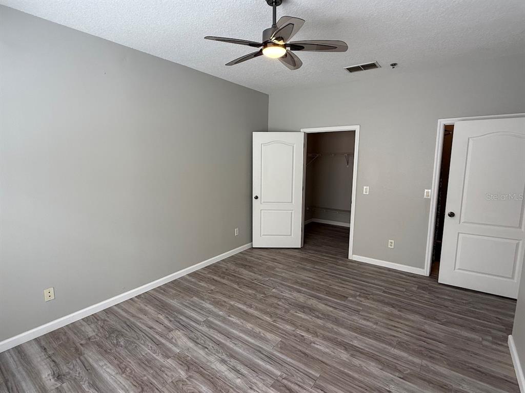 4817 Cypress Woods Drive, Unit 5203 Orlando, FL 32811 - Photo 20 of 22 an empty room with wooden floor and ceiling fan