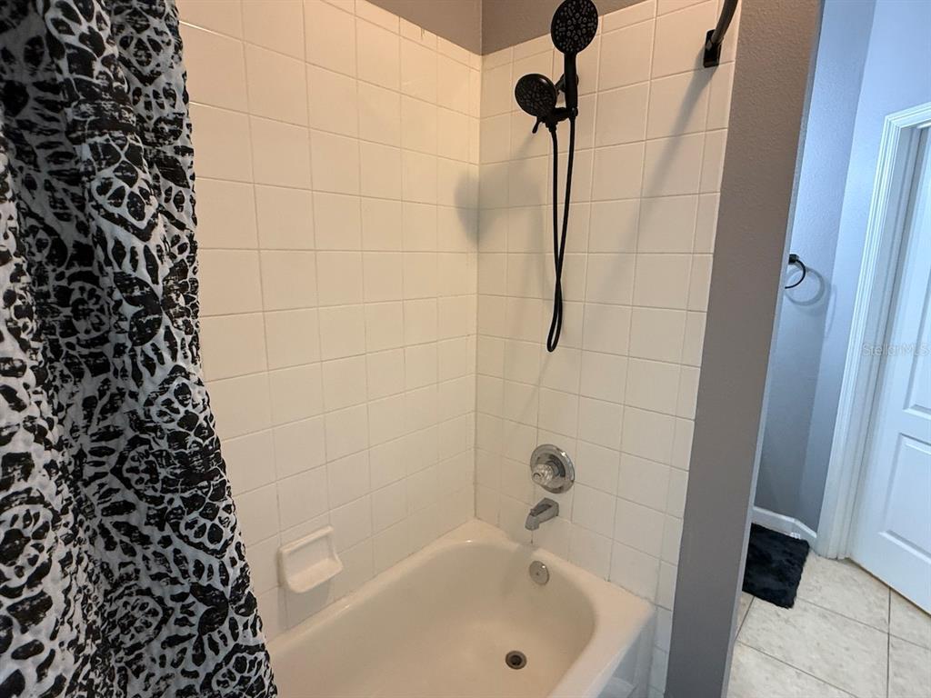 4817 Cypress Woods Drive, Unit 5203 Orlando, FL 32811 - Photo 21 of 22 a bathroom with a bathtub
