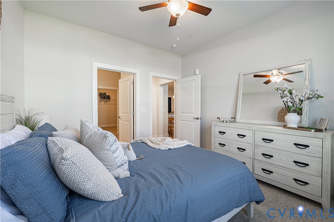 10525 Stony Blf Drive, Unit 204 Ashland, VA 23005 - Photo 25 of 36 a bedroom with a bed a chandelier and a dresser