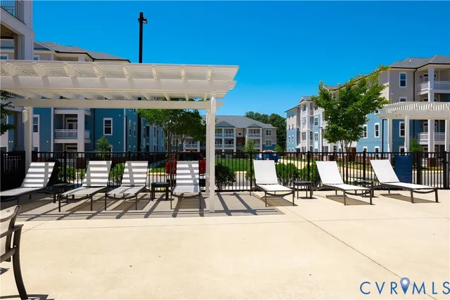 a view of a building with pool and chairs