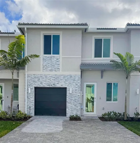 a front view of a house with a garden