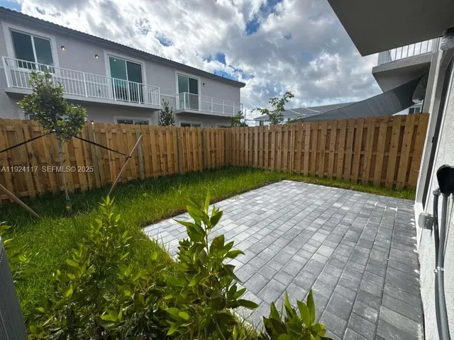 a view of a backyard with wooden fence