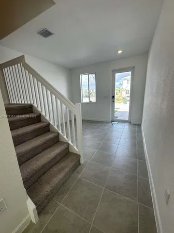 a view of a livingroom with wooden floor and stairs