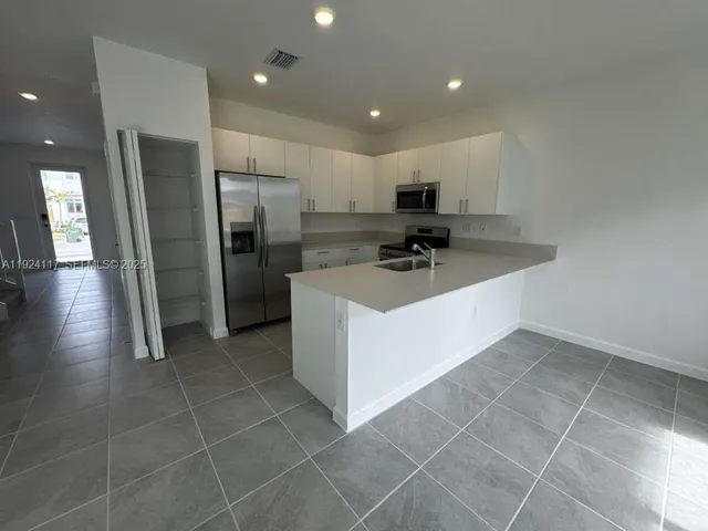 a kitchen with a sink a refrigerator and a stove
