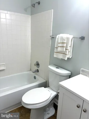 a white toilet sitting next to a bath tub