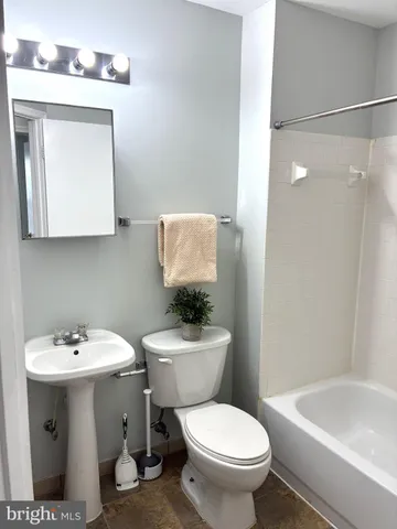 a bathroom with a sink mirror toilet and a bathtub