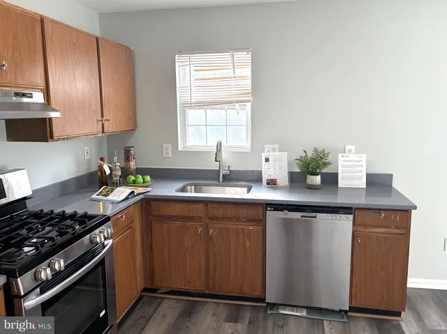 a kitchen with granite countertop a sink stainless steel appliances and cabinets