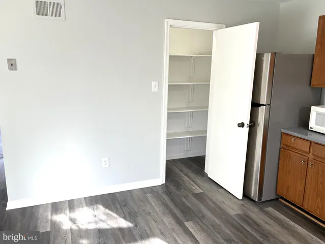 a view of walk in closet with wooden floor