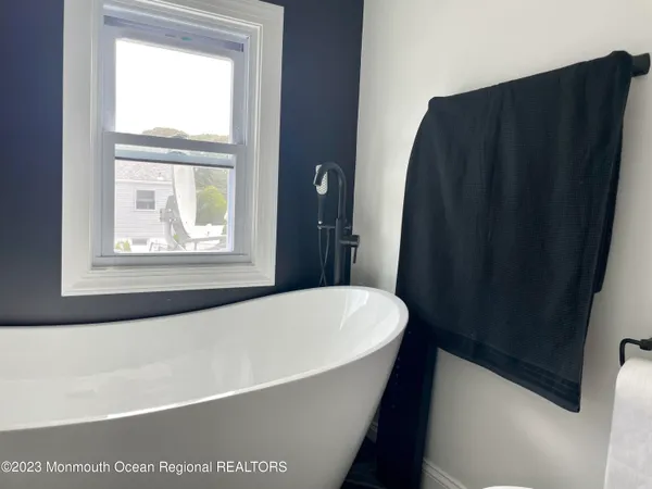 a white bath tub sitting in a bathroom next to a window