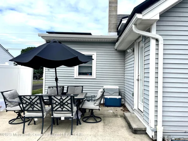 a view of a patio with table and chairs under an umbrella with wooden floor